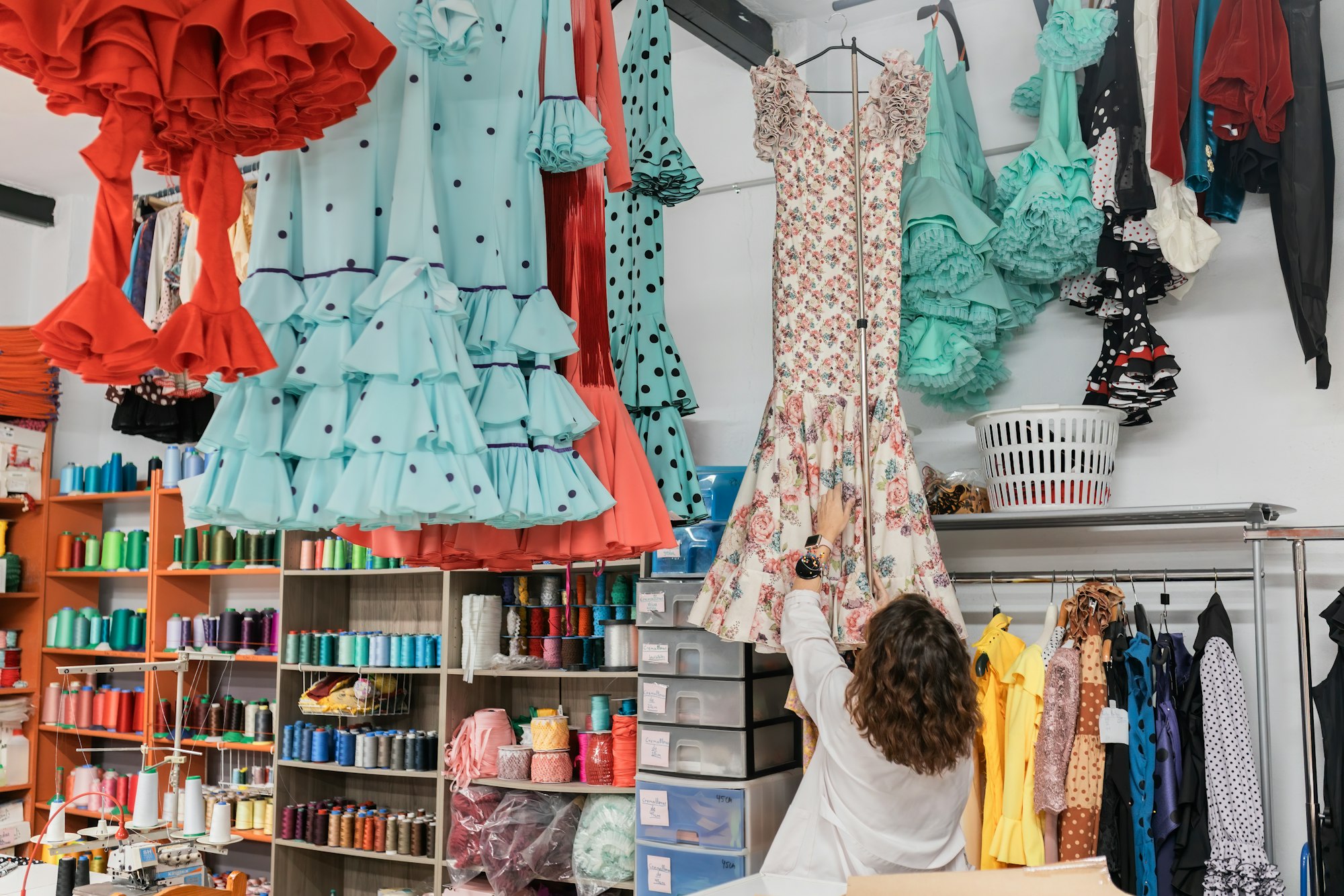 Woman choosing colorful clothes in shop